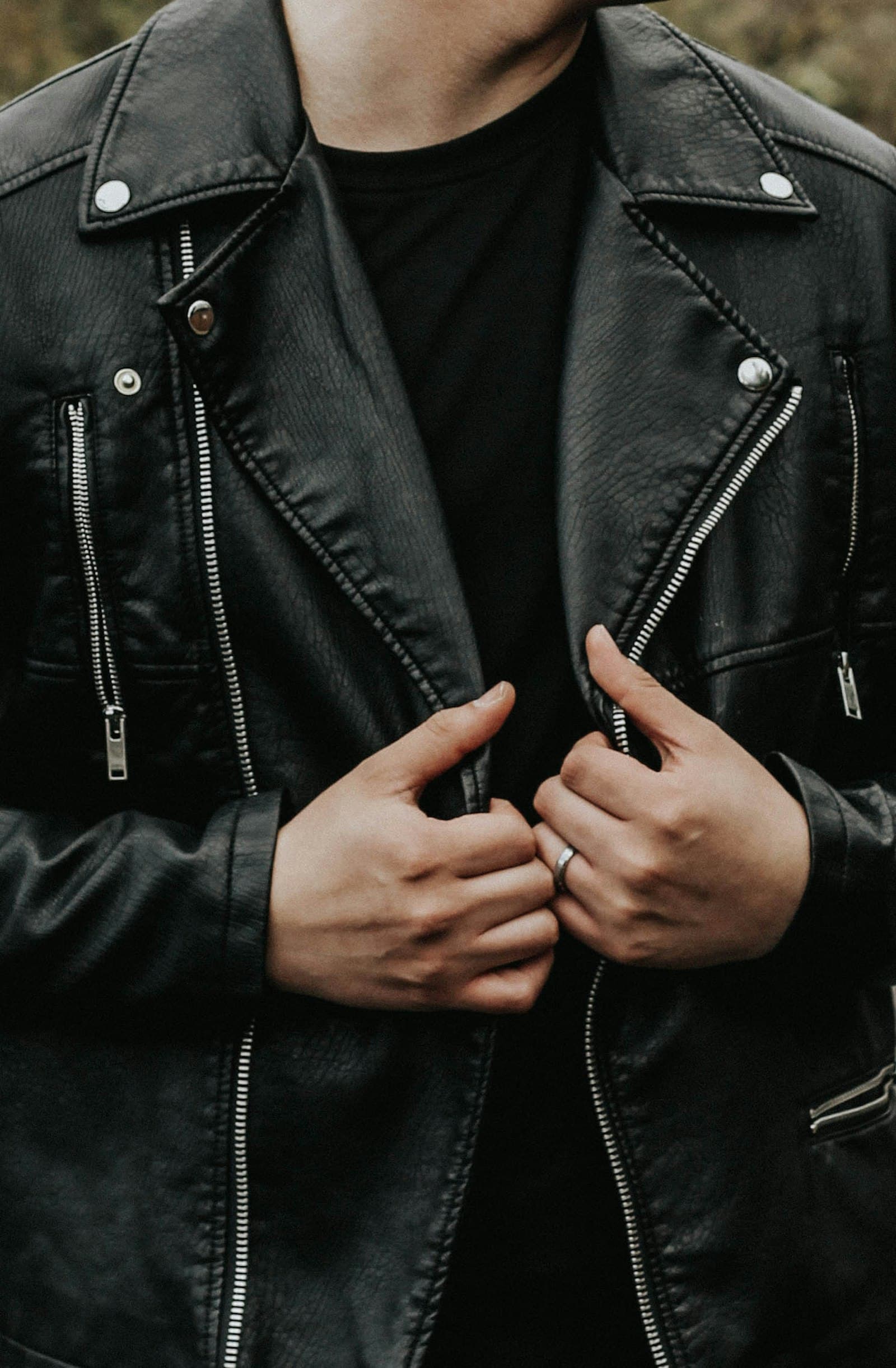 Close view of a black leather moto jacket with the collar turned up